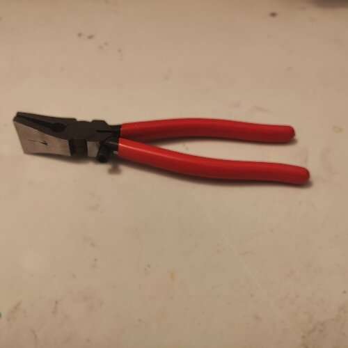 Running pliers up close showing the curved rubber face, center mark, and adjustment screw — the three parts to understand when learning how to use running pliers